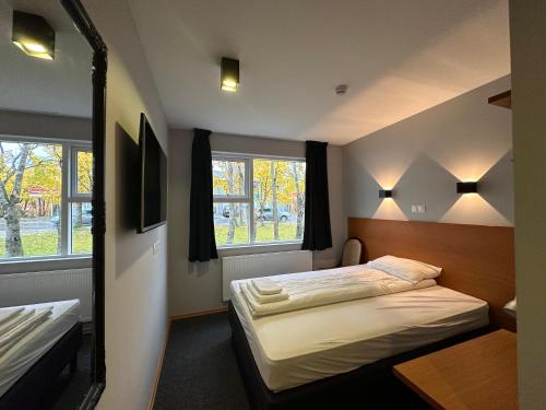 雷扎尔菲厄泽Hótel Austur的一间卧室设有两张床和两个窗户。