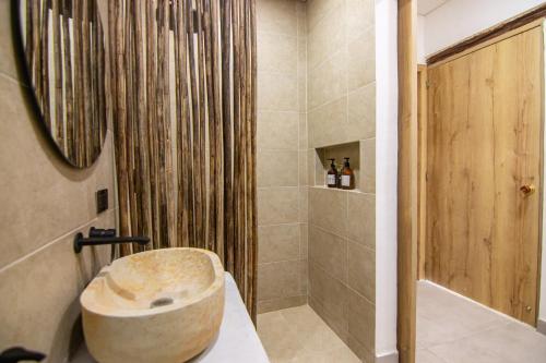 圣玛尔塔Hotel Boutique de playa - Casa Solhu的带淋浴和石质浴缸的浴室