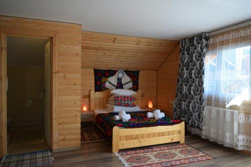 BrebCasa Vladicu的木制客房内的一间卧室,配有一张床