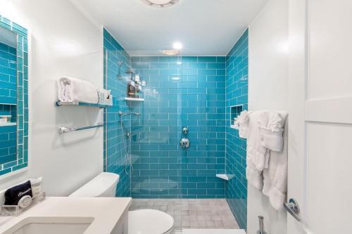 Dog CityVillas of the Galleon #6的蓝色瓷砖浴室设有卫生间和淋浴。