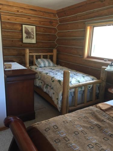 维勒蒙特Valemount Mountain Retreat Guesthouse的小木屋卧室设有床和窗户