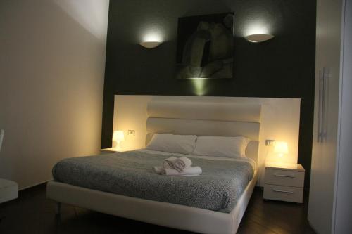 萨莱诺Palazzo della Poesia Casa Vacanze的一间卧室配有一张床,上面有两条毛巾