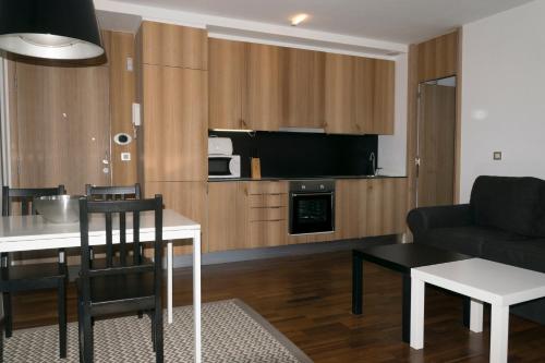 艾利亚德亚罗萨Apartamento de Mar y Playa en Illa de Arousa的厨房以及带桌子和沙发的客厅。