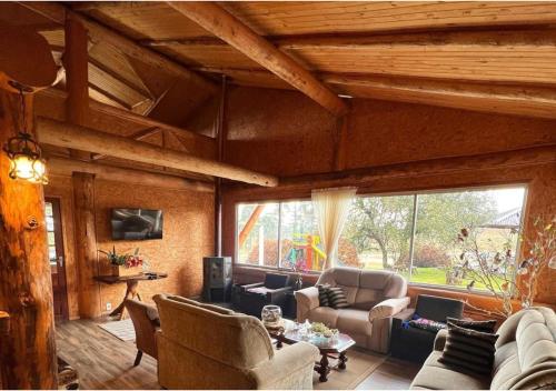 邦雅尔丁-达塞拉法泽恩达圣塔里塔农场旅舍的客厅配有家具和大窗户。