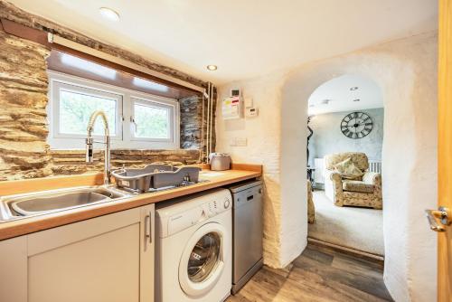 LlanfyrnachPendre Cottage的厨房配有水槽和洗衣机
