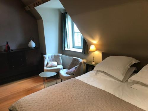 达默Het Oud Gemeentehuis-De Levensboom的卧室配有床、椅子和窗户。