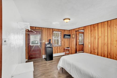 埃斯卡诺巴Eagles Nest Motel Unit 2的卧室设有白色的床和木墙