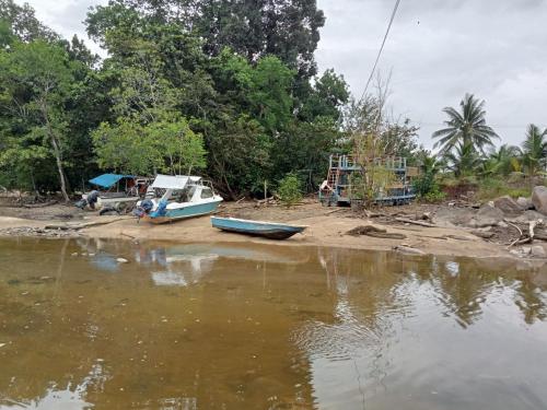 Kampong PandanThe BoatBnB的坐在河岸上的船