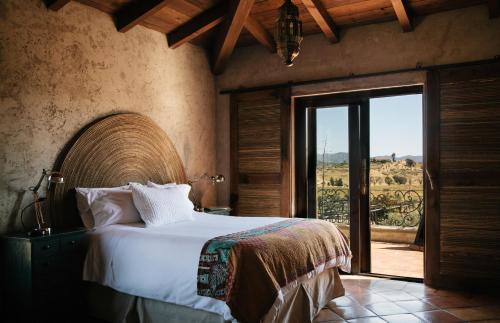瓜达鲁佩镇La Villa del Valle的一间卧室设有一张床和一个美景窗户。