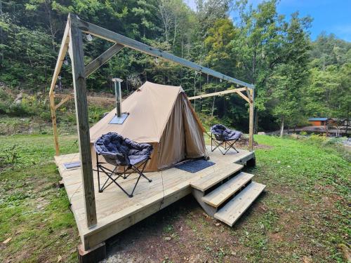 ButlerGlamping tent的木制甲板上的帐篷和两把椅子