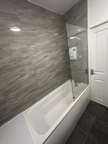 伯明翰Sutton Coldfield Apartment的浴室配有白色浴缸和淋浴。