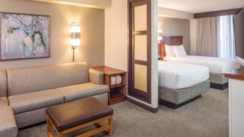 奥斯汀Hyatt Place Austin Arboretum Domain Area的酒店客房配有一张床、一张床和一张沙发
