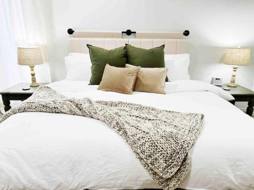 拉伯克NEW Magnolia Mansion-4400sqft Hot Tub & 2 Game Rms的一间卧室配有一张带两盏灯的大型白色床。