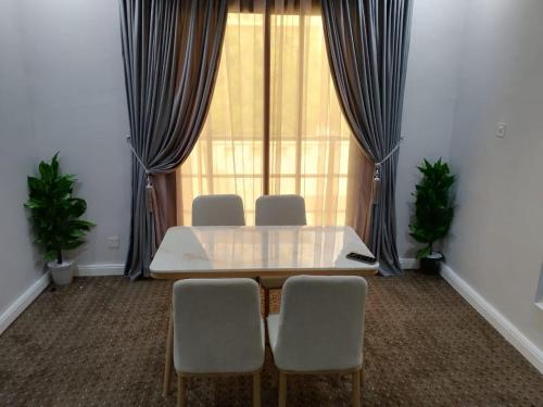 麦加شقق الكوثر الفندقية的客房设有桌椅和窗户。