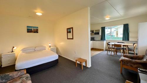 卡斯尔波因特Castlepoint Holiday Park & Motels的一间卧室设有一张床和一间用餐室