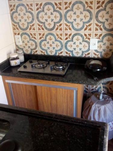 克拉鲁河畔卡尔穆Espaço Alternativo - a sua casa em Carmo do Rio Claro的厨房柜台设有炉灶和墙壁。