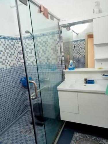 Proche de tout et au calme !的一间带玻璃淋浴和水槽的浴室