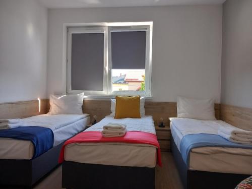 奥尔库什Jura Hotel Osiek的带窗户的客房内的两张床