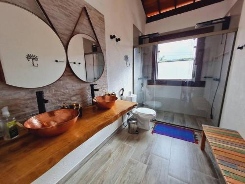 圣安娜杜里亚舒Casa do Lago Lapinha da Serra的浴室设有2个铜制盥洗盆和1个卫生间。