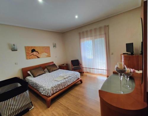 米兰德拉Quinta da Libelinha Alojamento Local - Mirandela的一间卧室配有一张床和一张玻璃桌