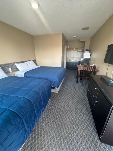 落基山庄Voyageur Motel的酒店客房配有两张床和一张书桌