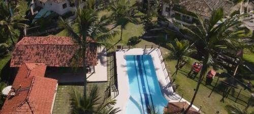 伊列乌斯Apartamento em Ilhéus Pé na Areia的享有棕榈树游泳池的顶部景致