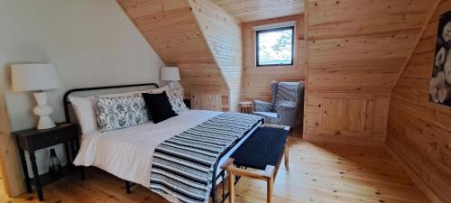 安蒂戈尼什Lochaber Homesteader Lodge的卧室配有床、椅子和窗户。