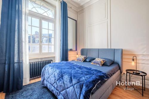 里摩日The Little Cérez Luminous Studio in the Heart of Limoges的一间卧室设有蓝色的床和窗户。