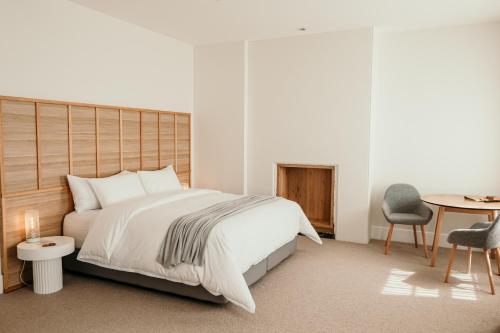 仙女港The Oak & Anchor Hotel的卧室配有1张床、1张桌子和1把椅子