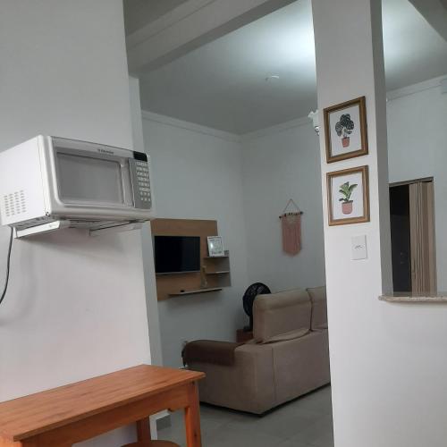 卡波布里奥Apartamento Confortável Perto da Praia的一间带微波炉和沙发的客厅