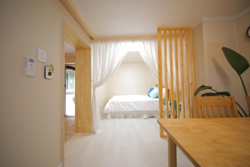 首尔Slow Vibe Myeongdong的一间卧室配有一张床、一张桌子和一个窗户。