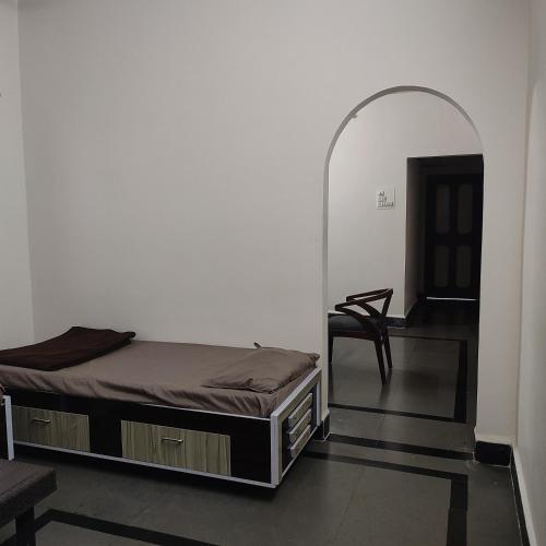 贝尔高姆Athiti HomeStay Villa的一间卧室,卧室内配有一张床和一把椅子