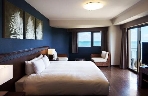 石垣岛GRANDVRIORESORT ISHIGAKIJIMA Ocean's Wing & Villa Garden的卧室配有一张白色大床和一把椅子