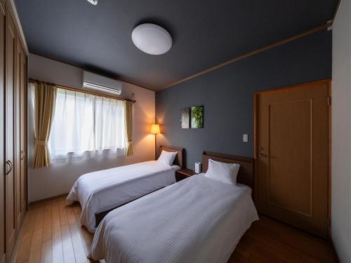 Ikeda1組限定　1棟貸切 「おとまり忠左衛門」　 グループや3世代旅行に最適　　　　的酒店客房设有两张床和窗户。
