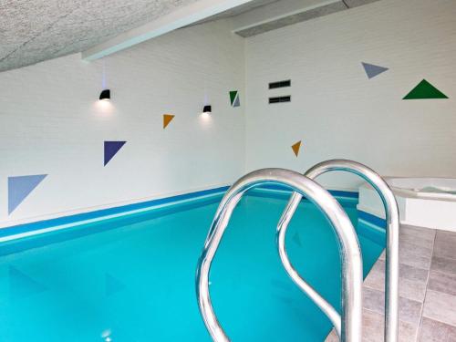 布拉万德12 person holiday home in Bl vand的墙上的蓝色水和三角形游泳池