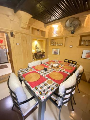 斋沙默尔Hamari Haveli的用餐室配有白色椅子和桌子