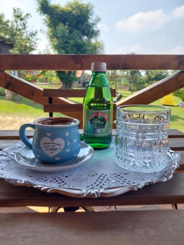 RipanjPalanačka Avlija 2的桌子,上面放着一瓶苏打水和一杯咖啡
