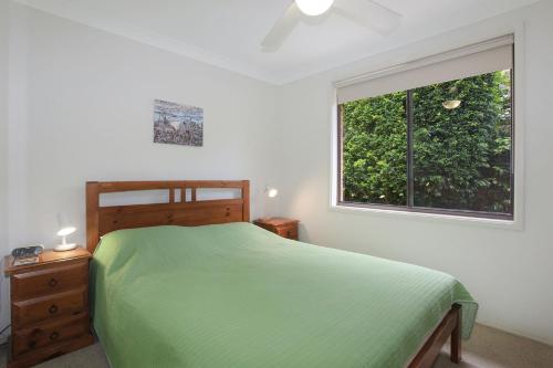 霍克斯内斯特All Decked Out的一间卧室设有一张绿色的床和一个窗户。