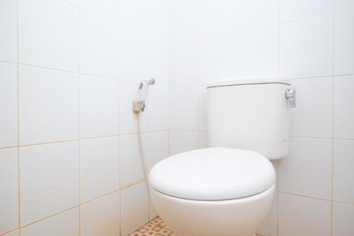 科贾扬RedDoorz Syariah at Griya Hanum Condoongcatur的白色瓷砖浴室内的白色卫生间
