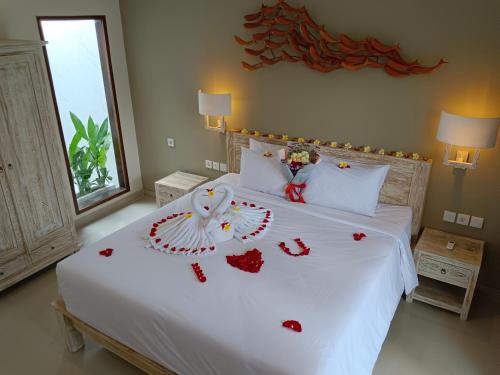 努沙杜瓦Kubu Garden Suites & Villas Nusa Dua的卧室配有一张红色的白色床