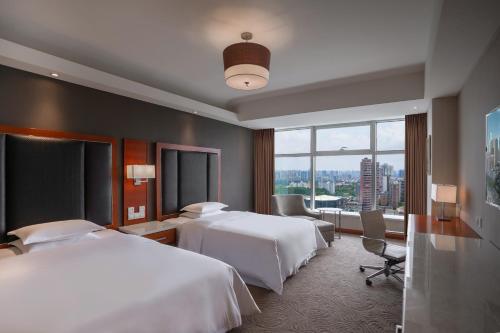 长沙长沙运达喜来登酒店的酒店客房设有两张床和大窗户。
