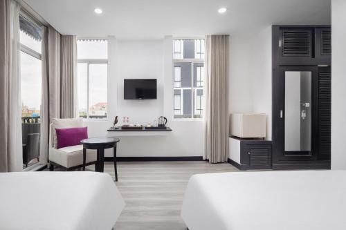 金边Apsor Palace Hotel的白色的客房配有两张床和电视。