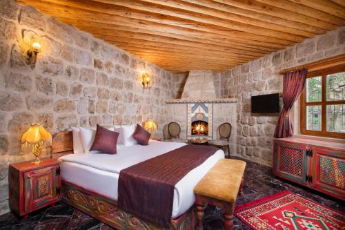 奥塔希萨尔Cappadocia Pema Cave Hotel的一间卧室设有一张床和石墙