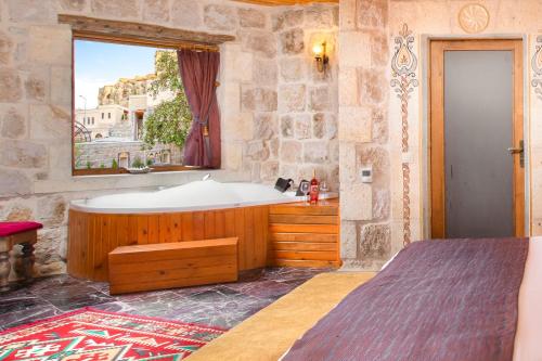 奥塔希萨尔Cappadocia Pema Cave Hotel的带浴缸和窗户的浴室