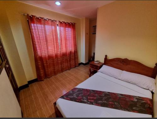 美岸Mojica Residencia的一间卧室配有床和红色窗帘的窗户