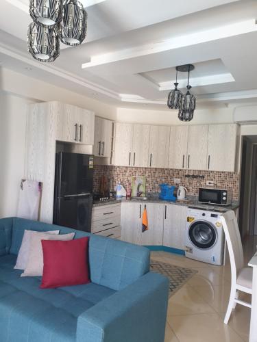 沙姆沙伊赫Sharm Hills的一间带蓝色沙发的客厅和一间厨房