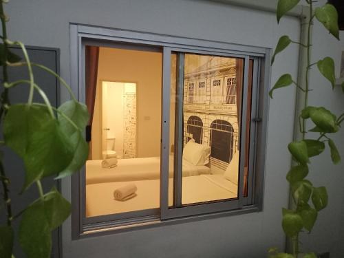 普吉镇Chino Town Gallery Alley - SHA Plus的窗户享有一张床的景致。