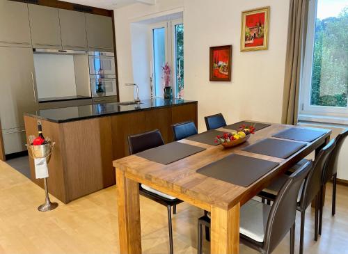 韦齐孔Gästehaus Casa Cecilia的厨房以及带木桌和椅子的用餐室。