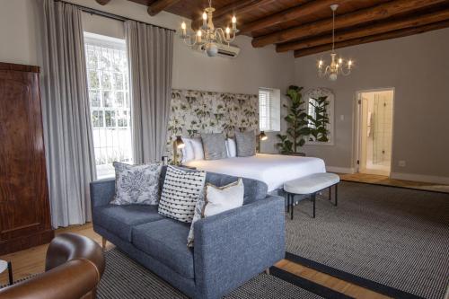 帕尔Laborie Jonkershuis的一间卧室配有一张床、一张沙发和一把椅子
