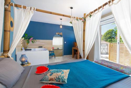 阿尔让河畔皮热Appartement jacuzzi 4 étoiles - Love Room Beauté的一间卧室设有一张大蓝色的床和大窗户